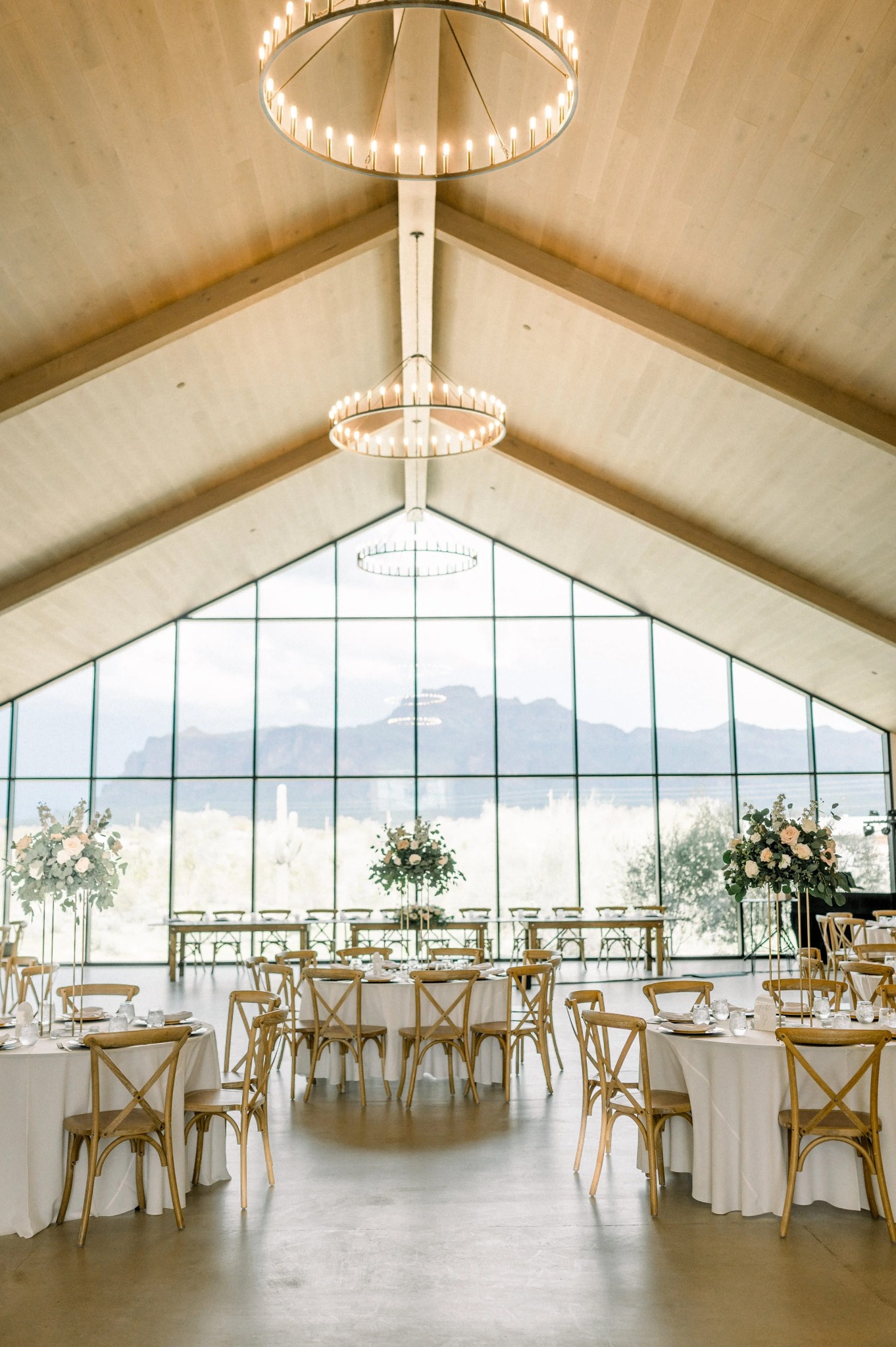 Salle de mariage moderne lumineuse avec vue sur la montagne et tables rondes