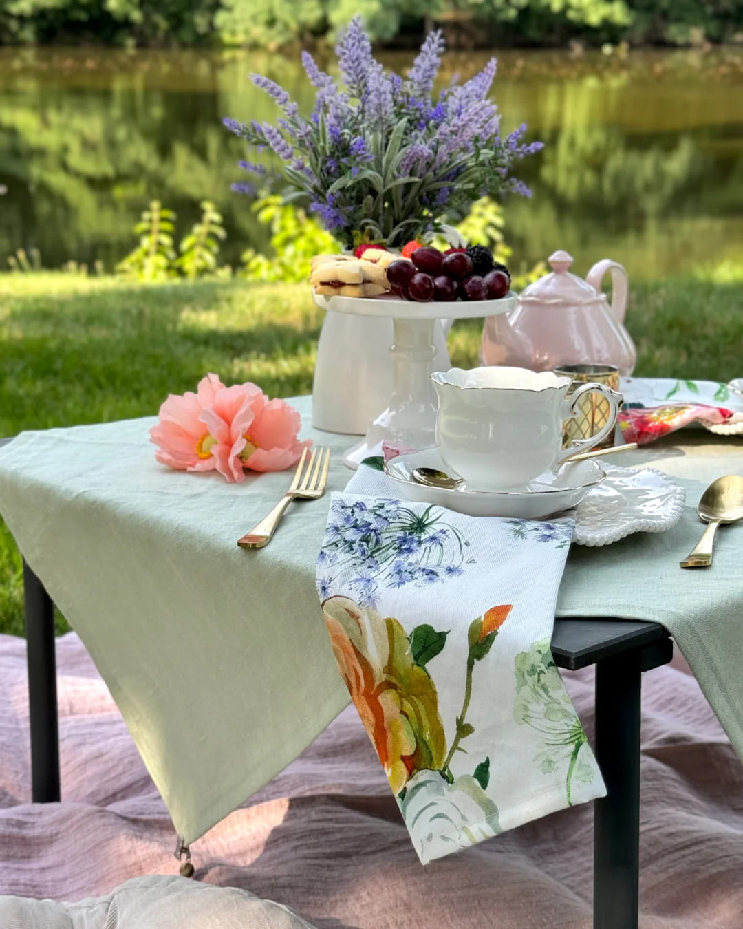 Table de goûter en jardin avec théière lavande, coupes en cristal et plateau de fruits